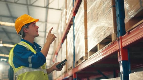 Man worker checks products stock inventory with digital tablet in the retail warehouse