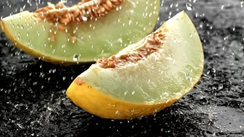 Des gouttes d'eau tombent sur un melon frais filmées par une caméra haute vitesse à 1000 images par seconde