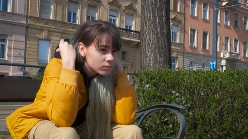 A teenage girl takes off her hood and smiles