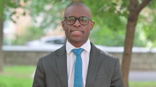 Homme d'affaires africain souriant regardant la caméra, portrait