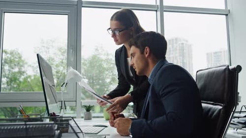 Business Colleagues Discussing Data at Computer in Office