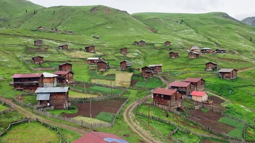 Drone Flight Above Old Highland Village Among Green Hills And Pastures