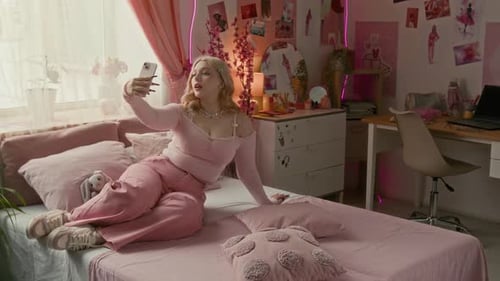 Young Adult Posing with Phone on Bed