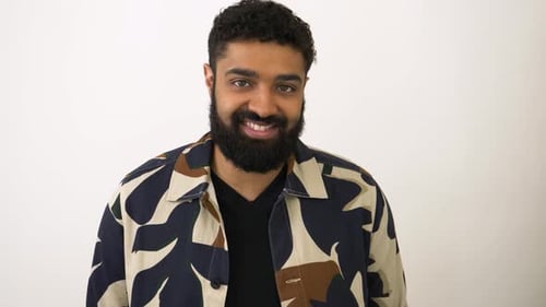 Smiling Man in Patterned Shirt Posing in Studio