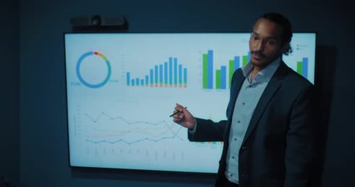 Man Presents Charts at Business Meeting