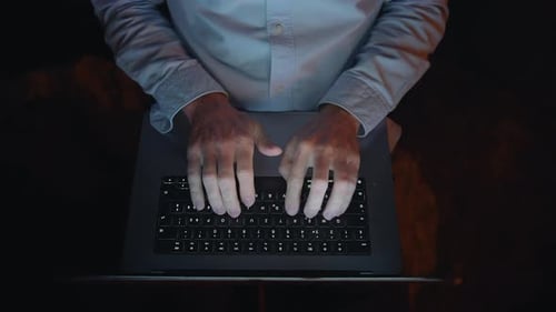 Man Typing on Laptop at Night Indoors
