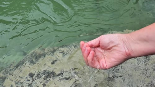 Clean water. hand collects clean water from a mountain river