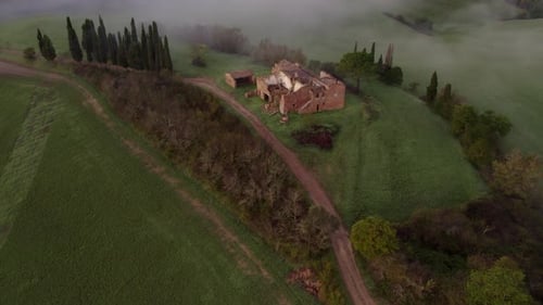 Aerial view of abandoned villa in foggy countryside, Italy.