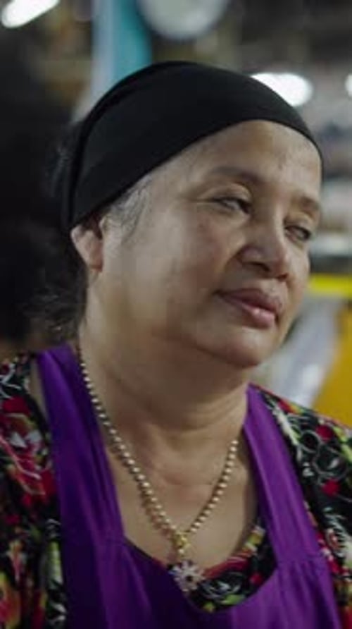 Mulher asiática sentada conversando e rindo com um cliente calmo e feliz em sua barraca de mercado