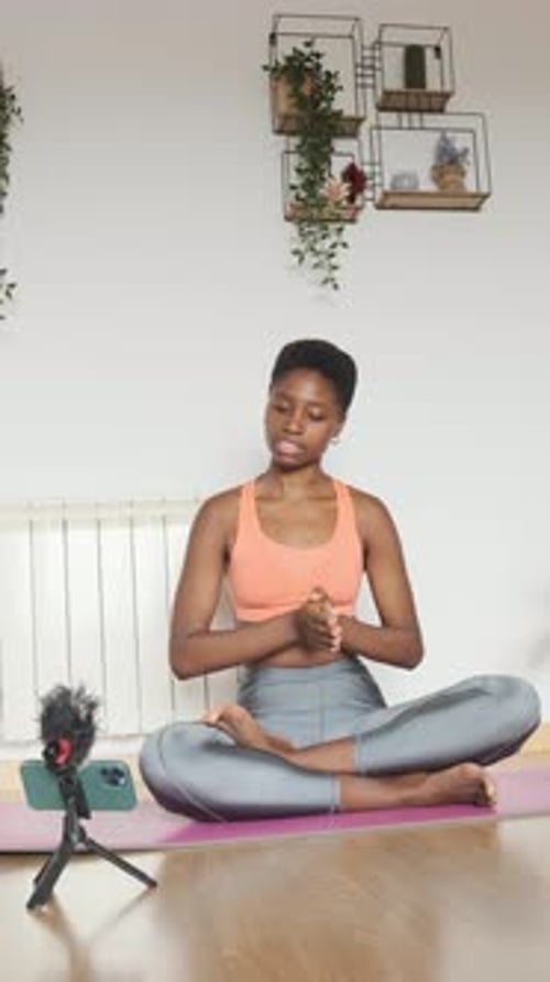 Mujer africana de fitness graba un Vídeo con un móvil en casa