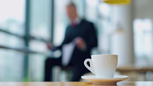 White cup of coffee on the table in the office.