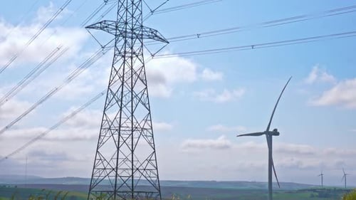 Wind Turbines and Power Line Tower on Sunny Day