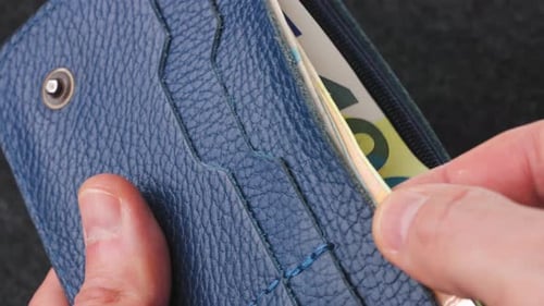 A Closeup View of Cash Being Stored in a Blue Wallet for Financial Purposes
