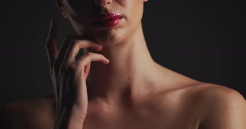 Hand, lips and woman in studio for skincare, dermatology and self care on black background