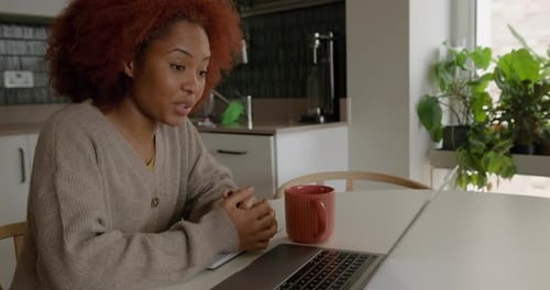 Woman Video Conferencing on Laptop at Home