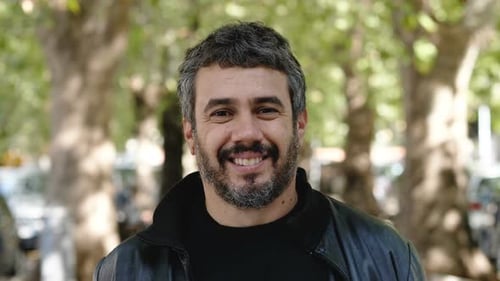 positivité, confiance en soi - jeune homme regardant la caméra et souriant - en plein air