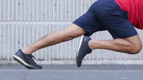 man doing running plank out doors in the city