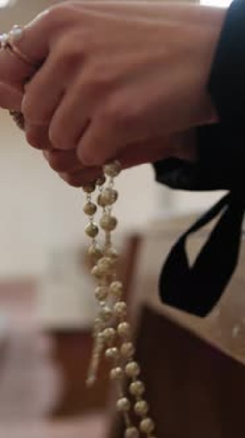 Woman Makes The Rosary Sitting Praying In Church For Peace
