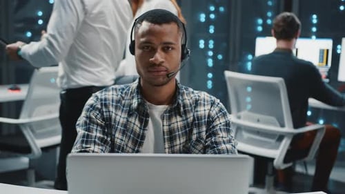 Man Works at Computer with Headset in Office
