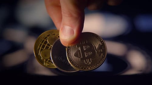 Fingers Holding Golden Crypto Currency Coins