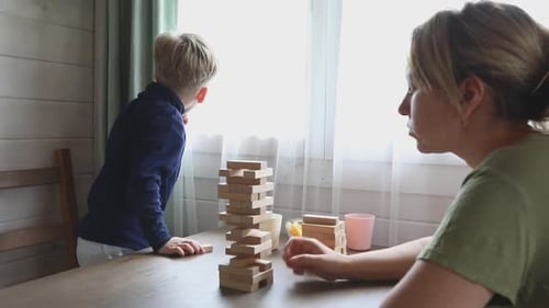 Mother and Son Play Jenga Game at Home