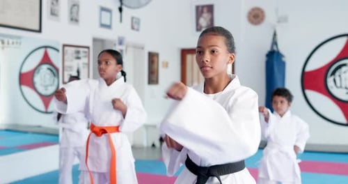 Focused Children Practice Martial Arts in Training