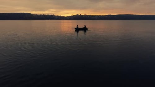 Two People in Boat on Lake at Sunset