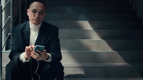 Office Worker Starting Dancing while Sitting on Stairs Indoors