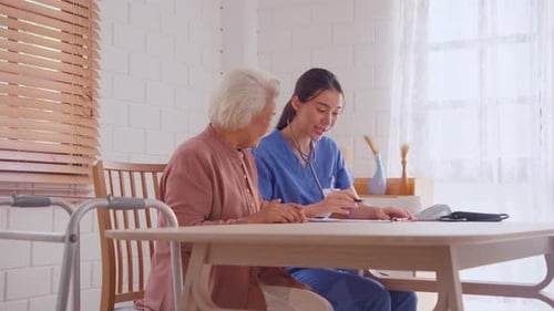 Asian young caregiver nurse examine senior woman patient at home.