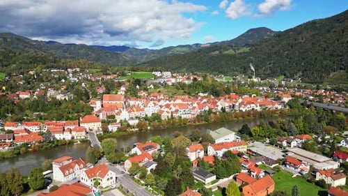 Aerial view of historic town with red roofs and mountains, Austria.