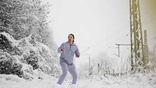 Man Practices Martial Arts Kicks in Snowy Winter Landscape