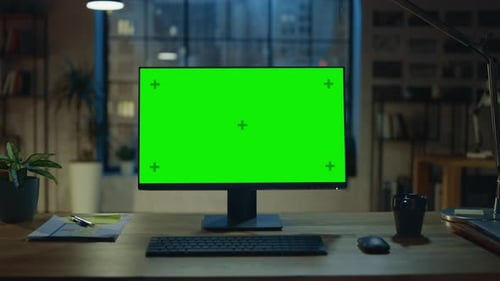 Desktop Computer with Mock-up Green Screen Standing on the Wooden Desk in the Modern Creative Offic