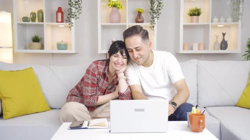 Couple Watching Laptop Together on Couch at Home