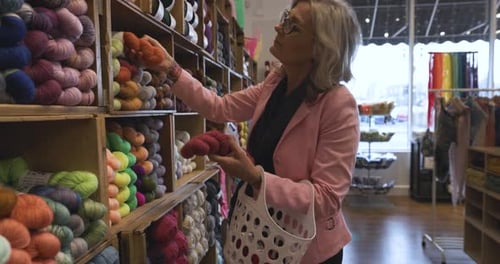 Female Customer Browsing Yarn At Shelves In Yarn Store Slow Motion