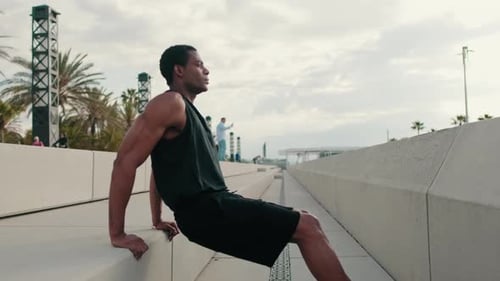 Man Doing Bench Tricep Dips Exercise by the Beach