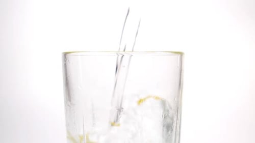 Clear Water Pouring Into Glass on White
