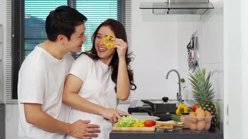 Young Couple Cooking Together in Kitchen at Home