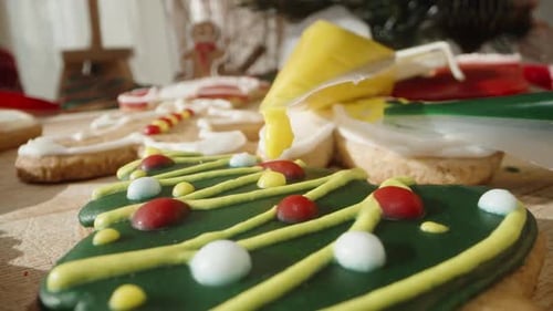 Detailed View of a Christmas Tree Cookie with Yellow and Red Icing Decorations, Creating a Festive