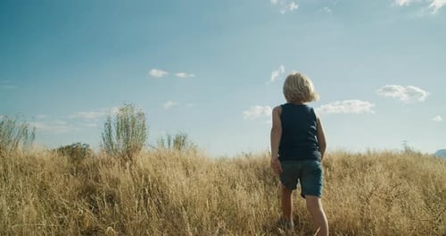 Child Boy Walk on Mountain Meadow on Evening at Summer Vacation