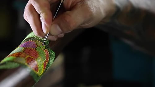 artist paints dots of sea turtle for didgeridoo pointillism panning view