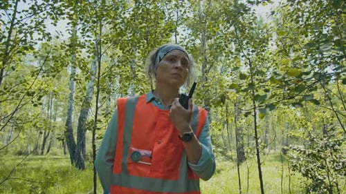 Female Rescuer Looking for Lost Tourist in Woods