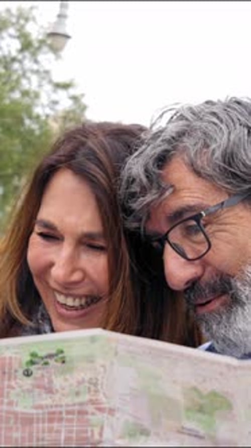 Smiling Couple Looking at Map in City