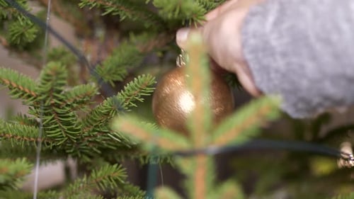 Person hand place christmas tree toy on christmas tree