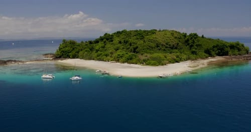 Aerial view of a magnificent landscape: an island with white beach, crystal clear sea, palm trees.