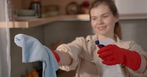 Woman Holding Cleaning Spray Bottle and Rag
