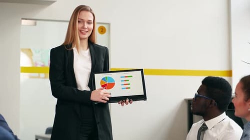 Woman Presenting Data to Coworkers in Modern Office