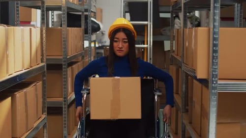 Asian Woman in Wheelchair Carrying Cardboard Boxes