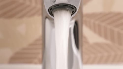 Close Up of Running Faucet in Bathroom