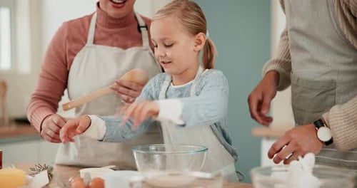 Girl Cracks Egg With Family Baking in Kitchen