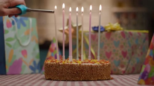 Lighting Candles on Festive Birthday Cake with Gifts